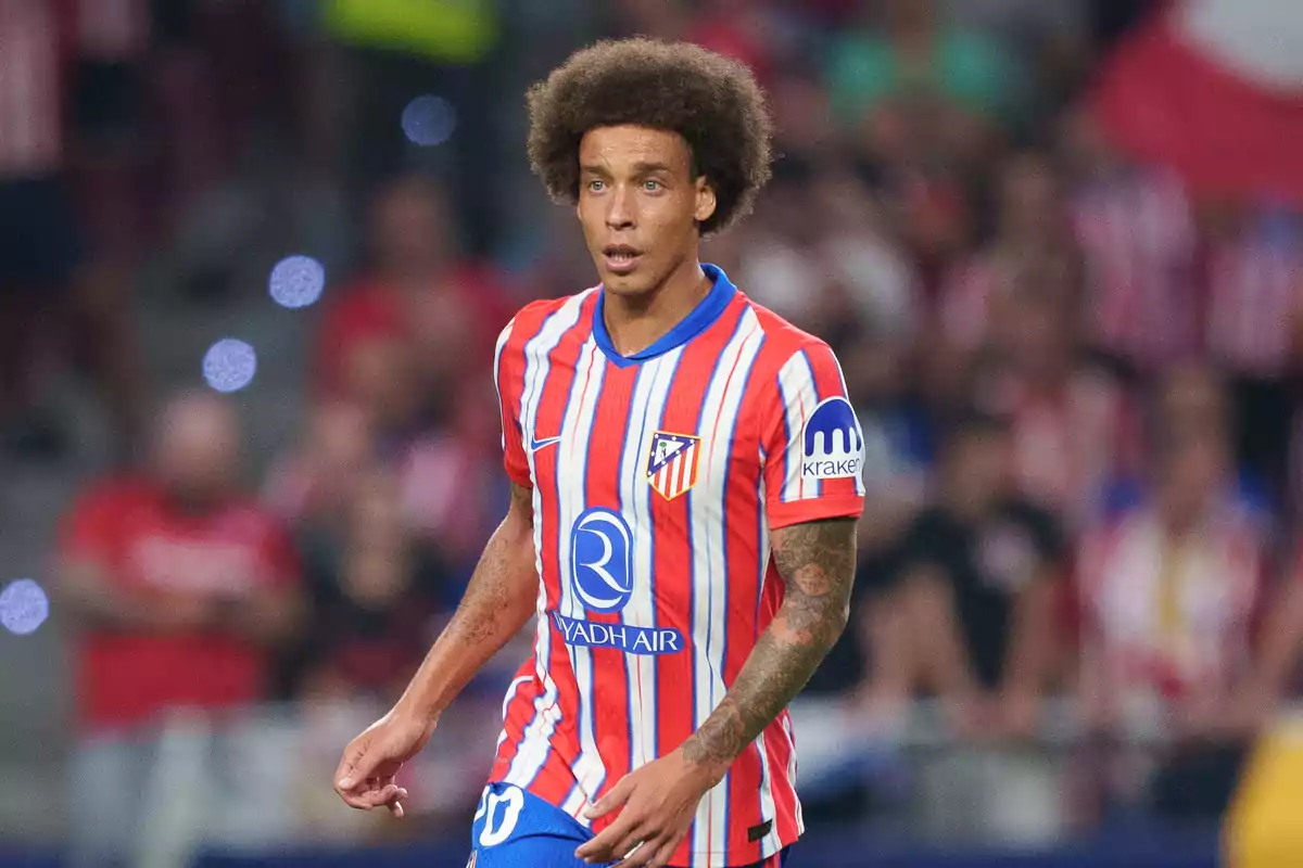 Jugador de fútbol con uniforme a rayas rojas y blancas en el campo durante un partido.