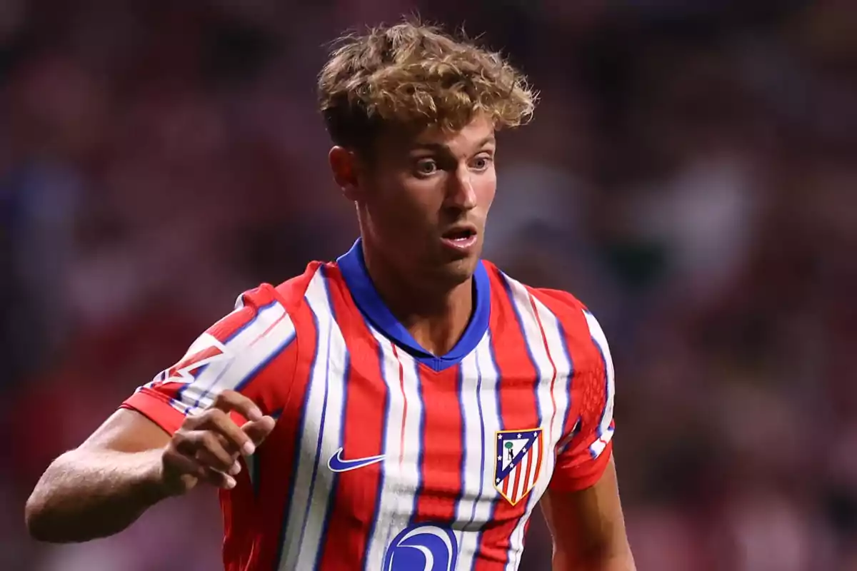 Un jugador de fútbol con la camiseta del Atlético de Madrid en el campo.