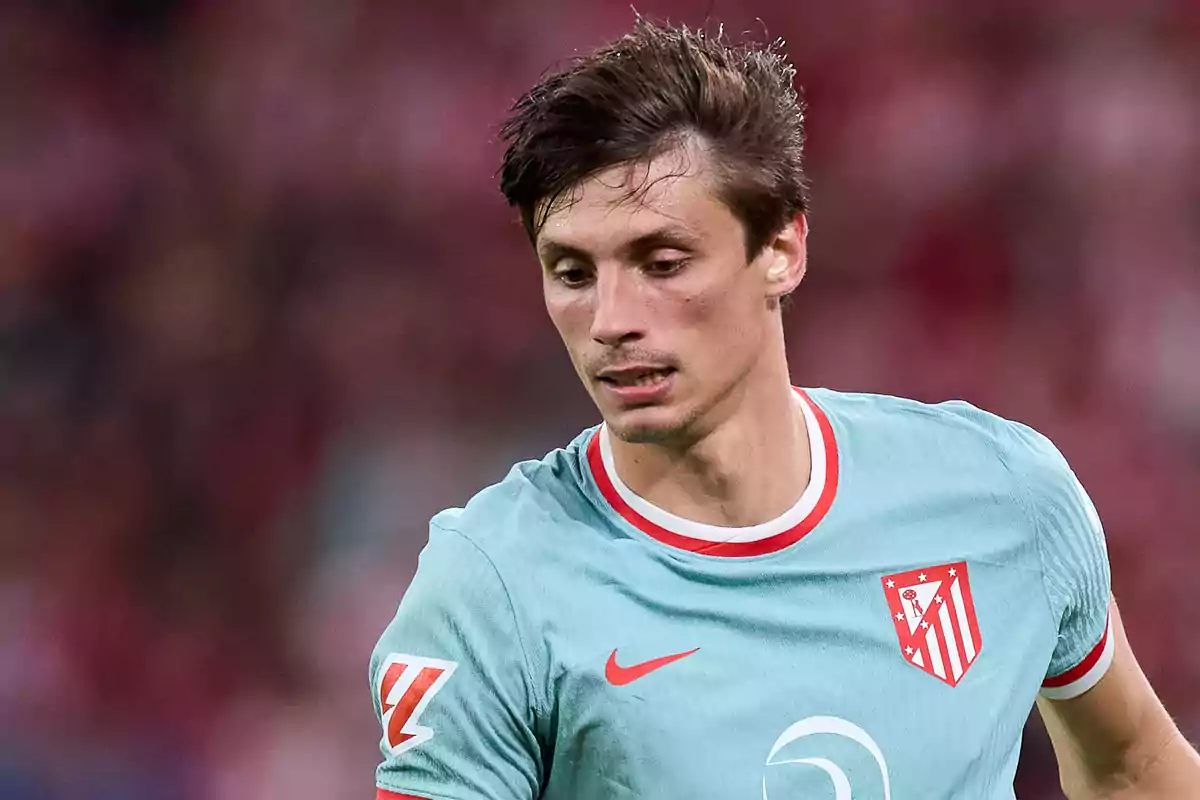 Jugador de fútbol con camiseta celeste del Atlético de Madrid en un partido.