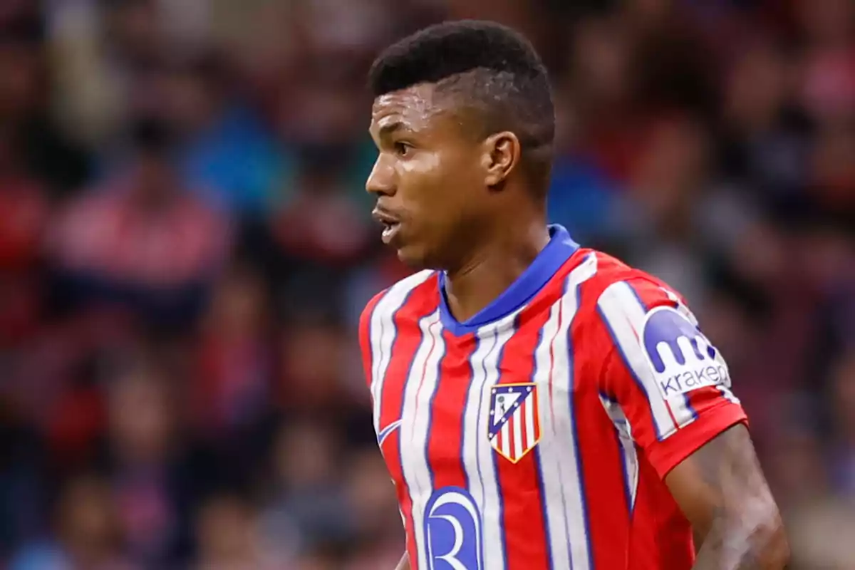 Un jugador de fútbol con el uniforme del Atlético de Madrid en el campo.