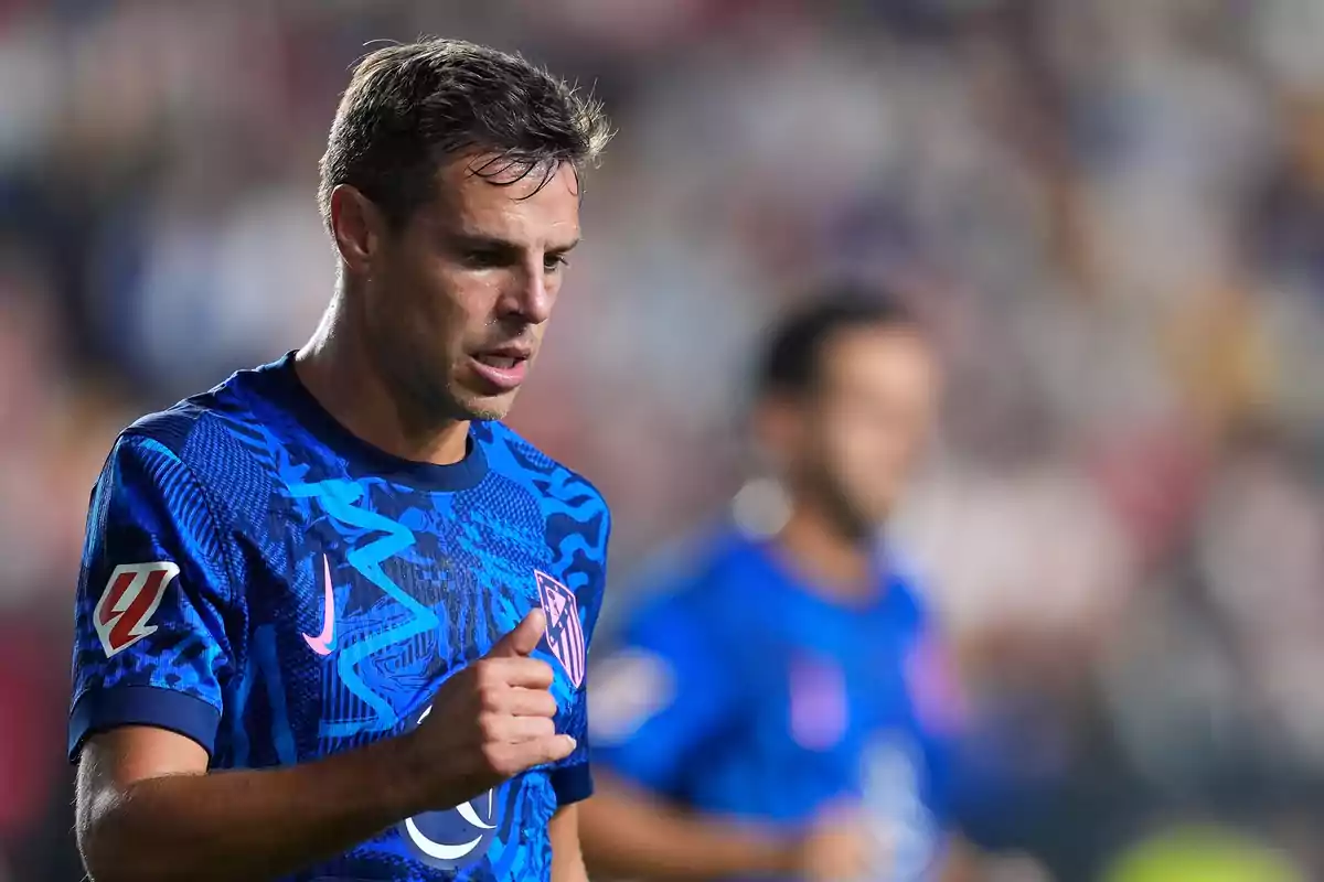 Jugador de fútbol con camiseta azul en el campo de juego