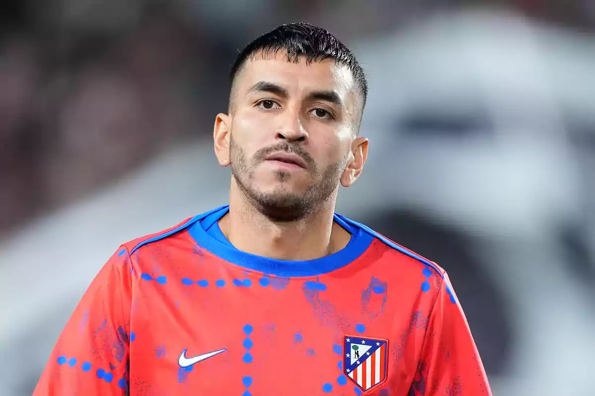 Un jugador de fútbol con una camiseta de entrenamiento roja del Atlético de Madrid.