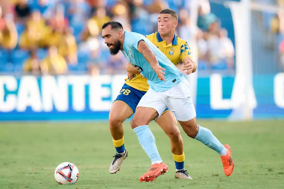 Dos jugadores de fútbol compiten por el balón en un partido.