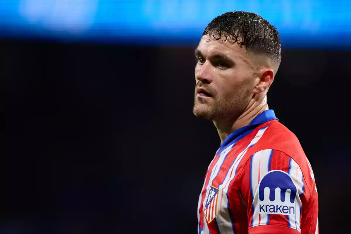 Jugador de fútbol con camiseta del Atlético de Madrid durante un partido.