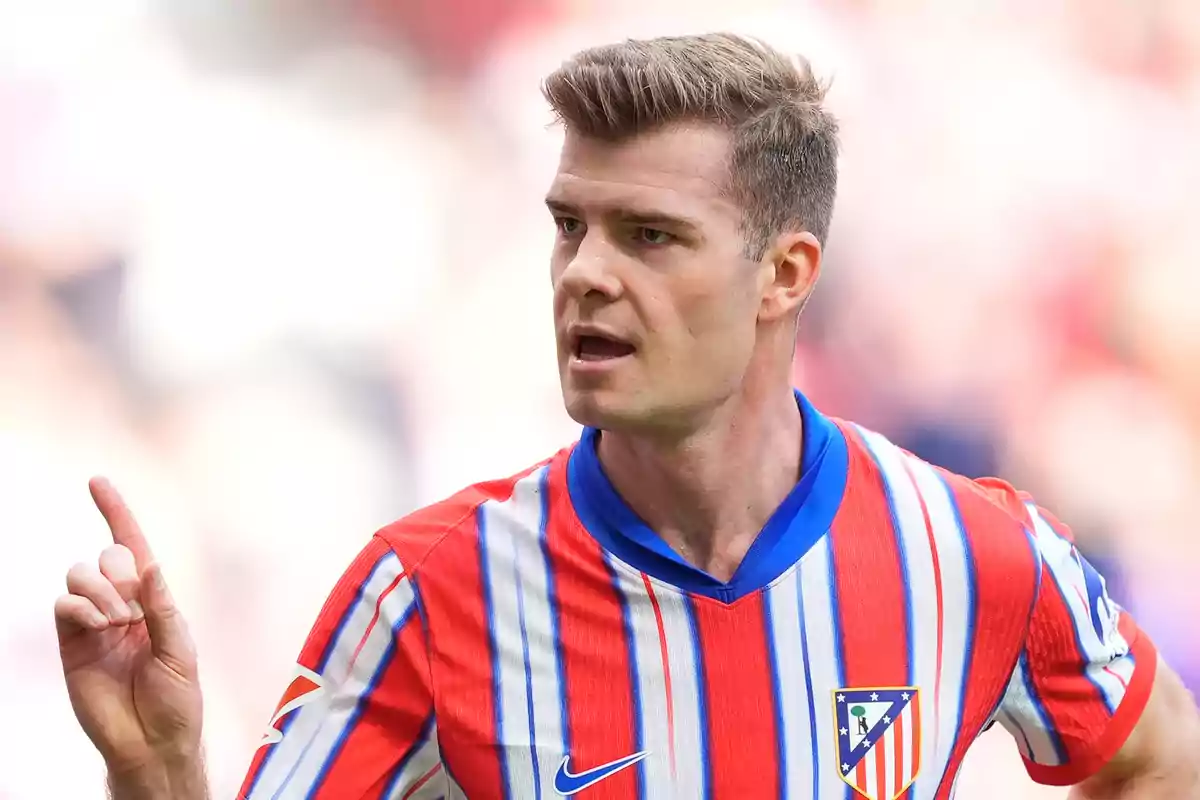 Jugador de fútbol con uniforme del Atlético de Madrid gesticulando durante un partido.