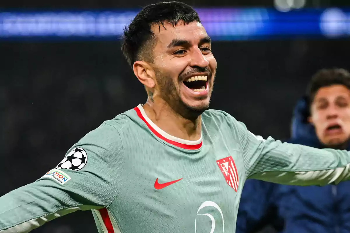 Soccer player celebrating with a big smile during a match.