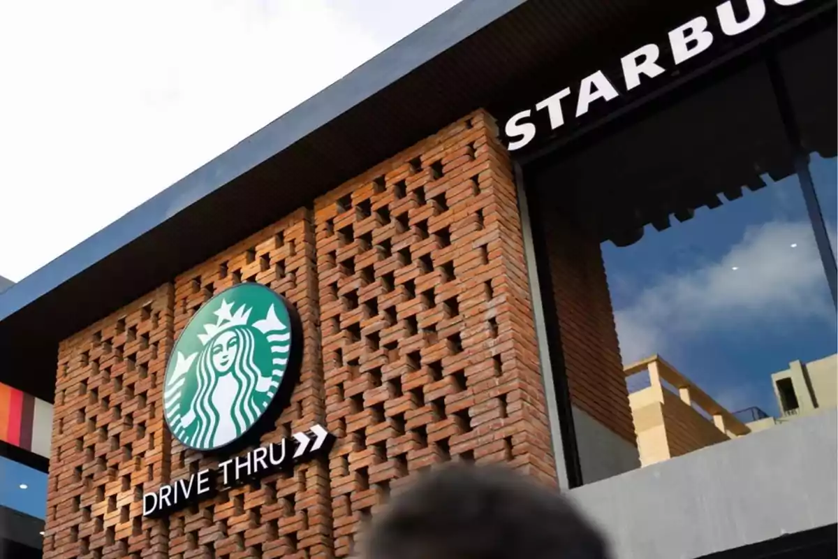 Facade of a coffee shop with a drive-thru sign and a brick design.