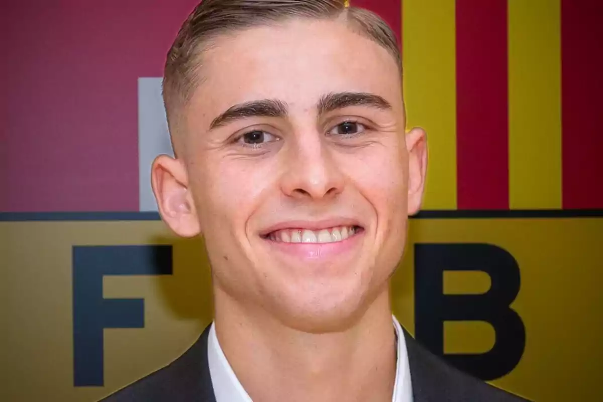 Un hombre joven sonriendo frente a un fondo con letras y colores rojo y amarillo. Un hombre joven sonriendo frente a un fondo con letras y colores rojo y amarillo.