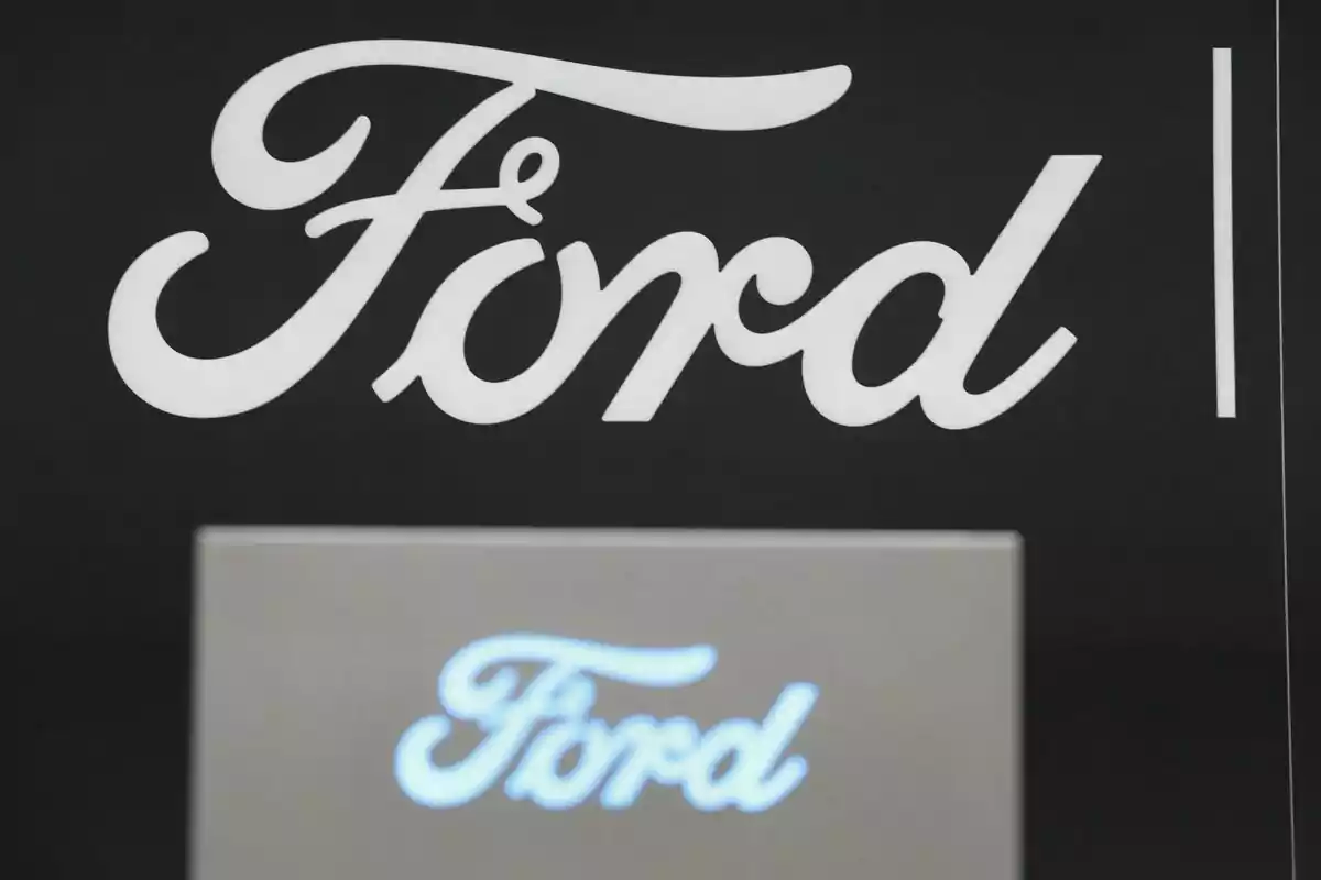 Logo de Ford en color blanco sobre fondo negro con un reflejo borroso del mismo logo en la parte inferior Logo de Ford en color blanco sobre fondo negro con un reflejo borroso del mismo logo en la parte inferior
