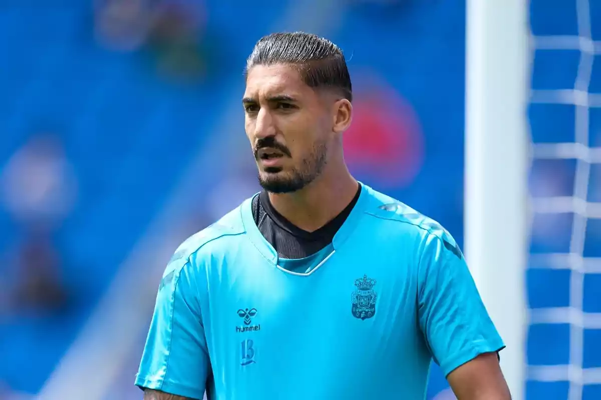 Un jugador de fútbol con uniforme azul claro en un campo de juego.