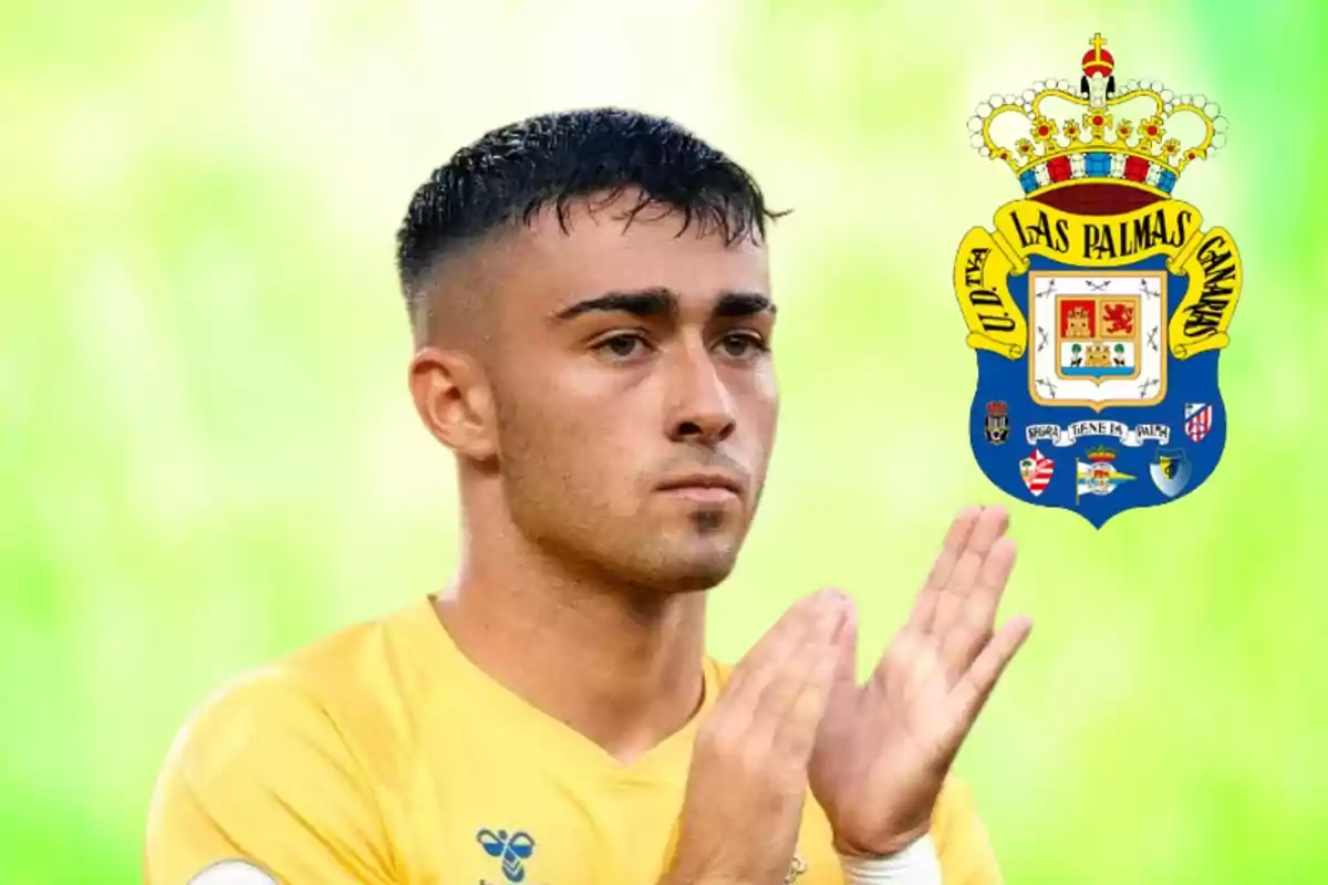 Jugador de fútbol aplaudiendo con el escudo de la UD Las Palmas al fondo.