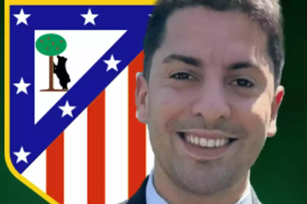 Un hombre sonriente con el escudo del Atlético de Madrid de fondo.