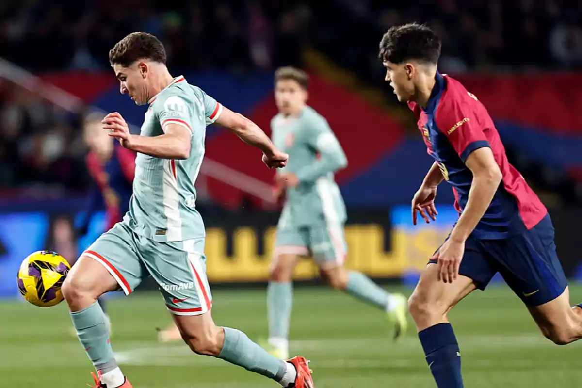 Dos jugadores de fútbol compiten por el balón en un partido.