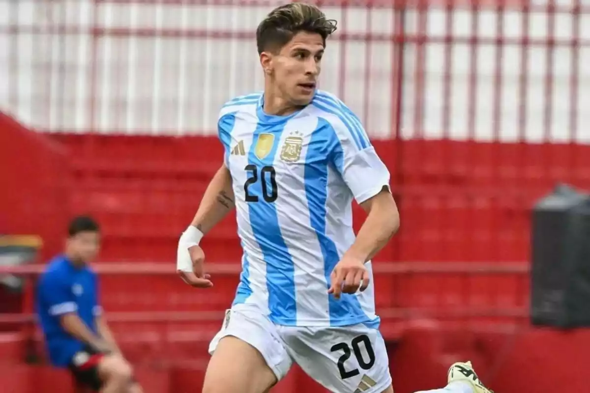 Jugador de fútbol con la camiseta de Argentina número 20 corriendo en el campo.