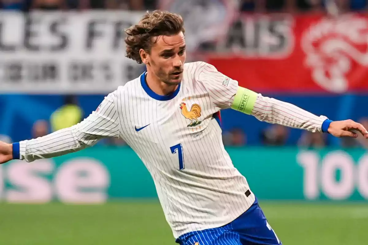 Jugador de fútbol con uniforme blanco y azul en acción durante un partido.