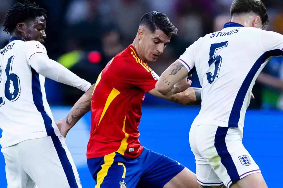 Jugadores de fútbol de los equipos de España e Inglaterra disputando el balón durante un partido.