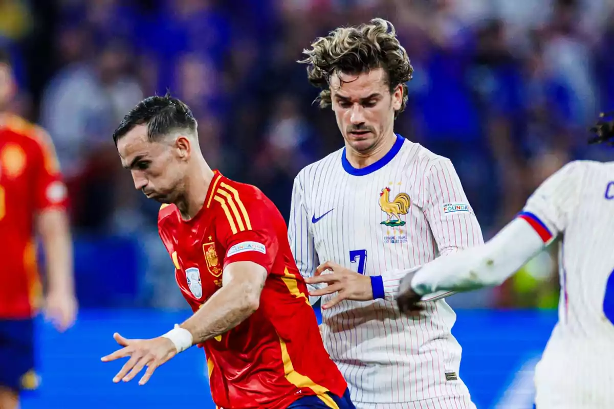 Jugadores de las selecciones de España y Francia disputando un balón durante un partido de fútbol.