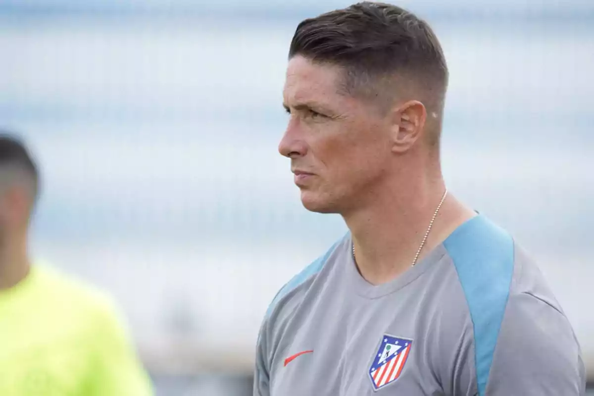 Hombre con camiseta de entrenamiento del Atlético de Madrid mirando hacia la derecha.