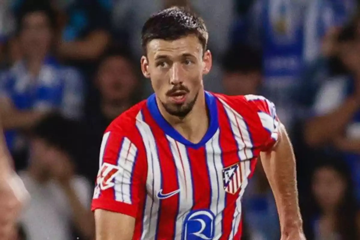 Un jugador de fútbol con uniforme rojo y blanco a rayas en el campo de juego.