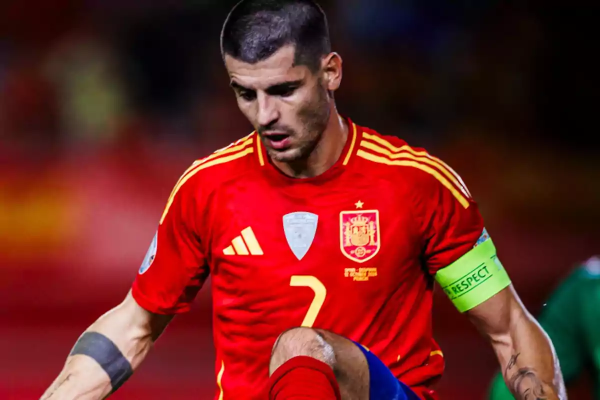 Jugador de fútbol con uniforme rojo de la selección española durante un partido.