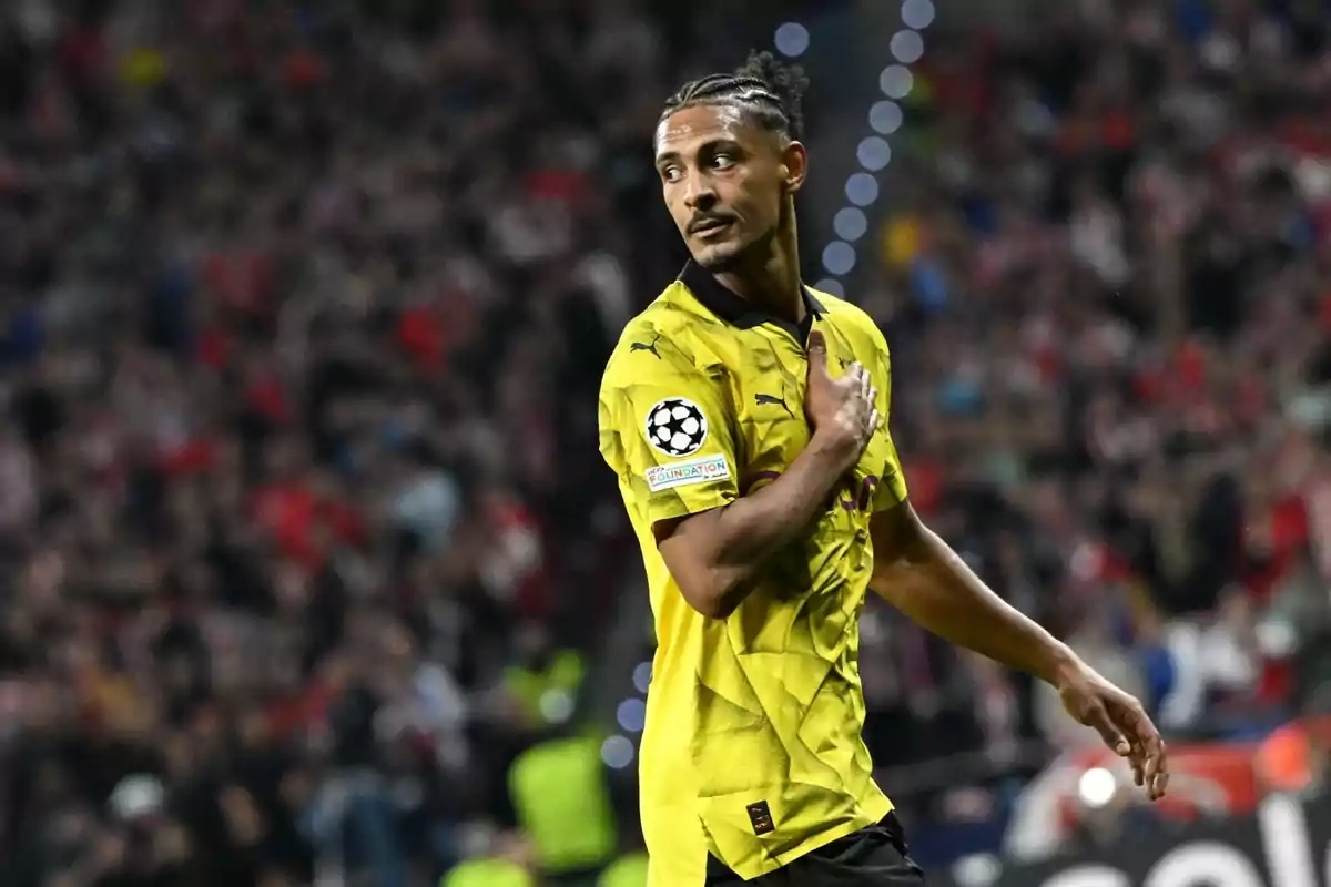 Jugador de fútbol con camiseta amarilla del Borussia Dortmund en un partido de la Liga de Campeones.