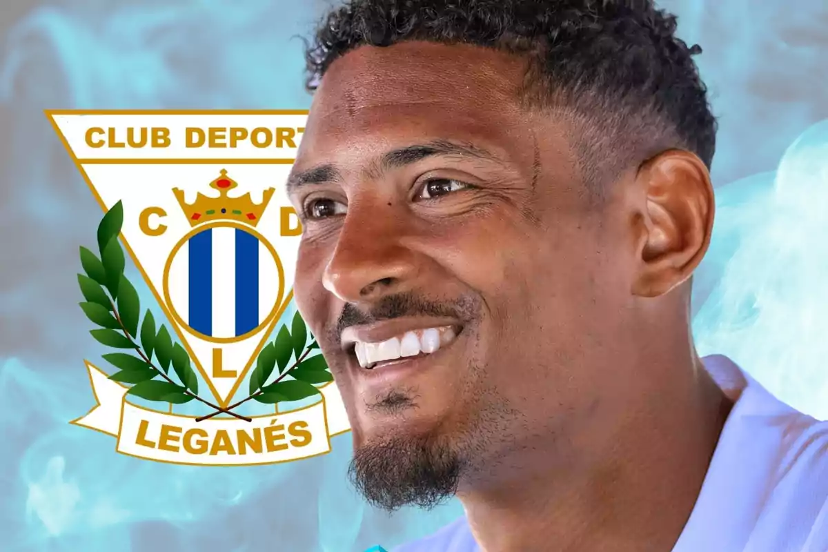 Un hombre sonriente con el logo del Club Deportivo Leganés de fondo.