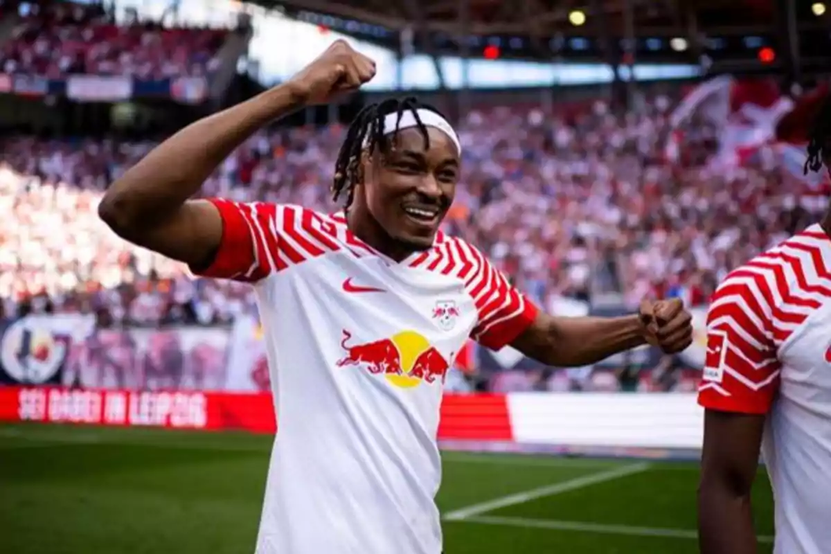 Jugador de fútbol celebrando en el campo con la camiseta del RB Leipzig.