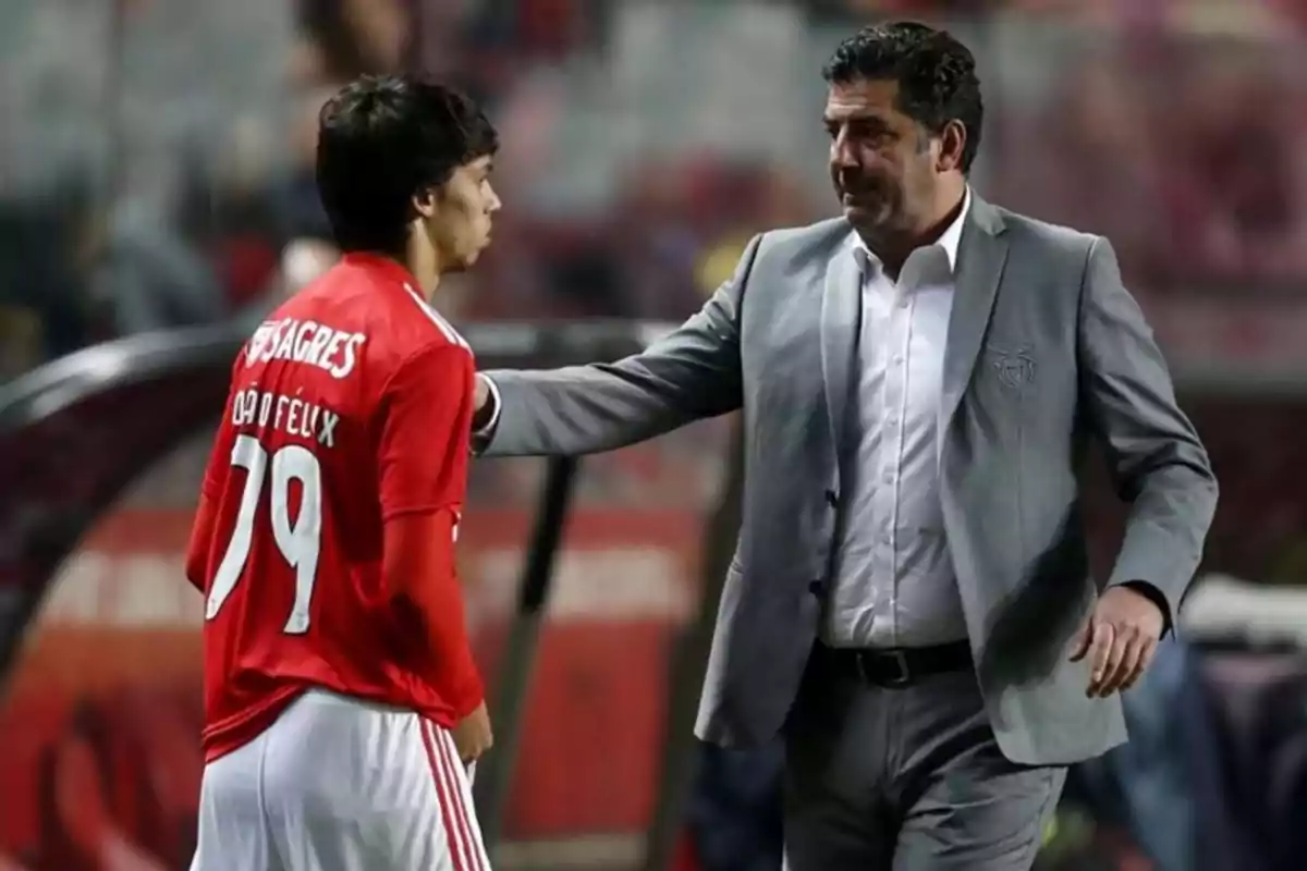 A football coach gives instructions to a player on the field.