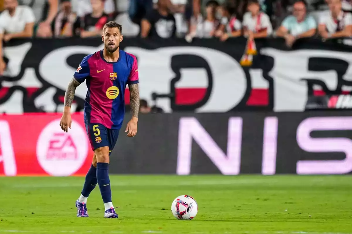 Un jugador de fútbol con el uniforme del FC Barcelona está en el campo durante un partido con una multitud de espectadores en el fondo. Un jugador de fútbol con el uniforme del FC Barcelona está en el campo durante un partido con una multitud de espectadores en el fondo.