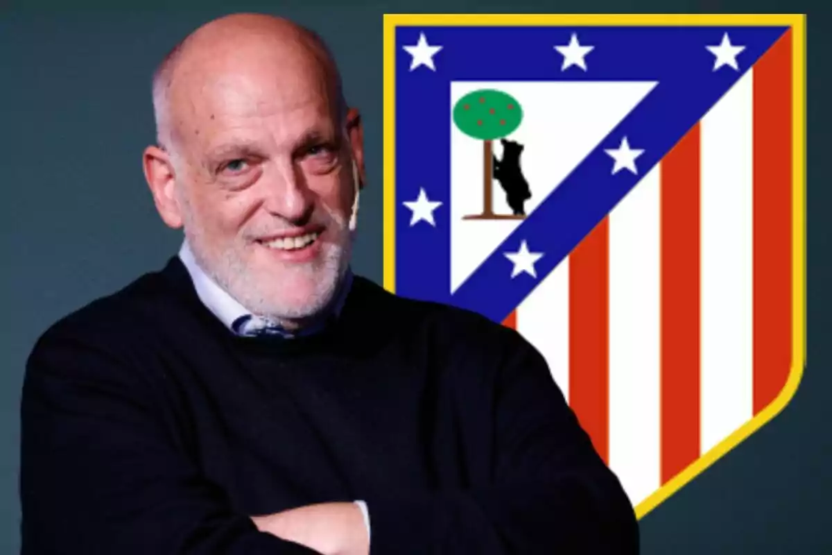 Un hombre sonriente con un micrófono en la oreja, frente al escudo del Atlético de Madrid.