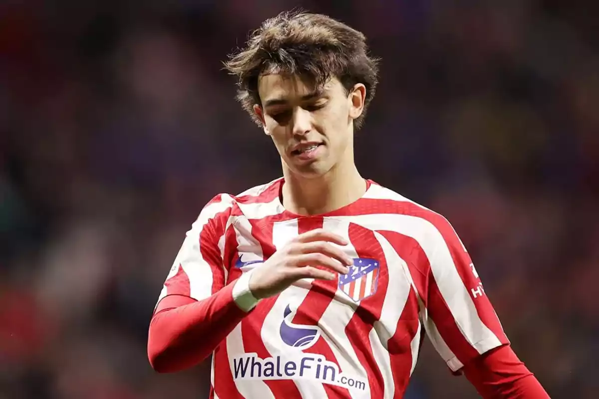 Jugador de fútbol con camiseta del Atlético de Madrid en el campo.