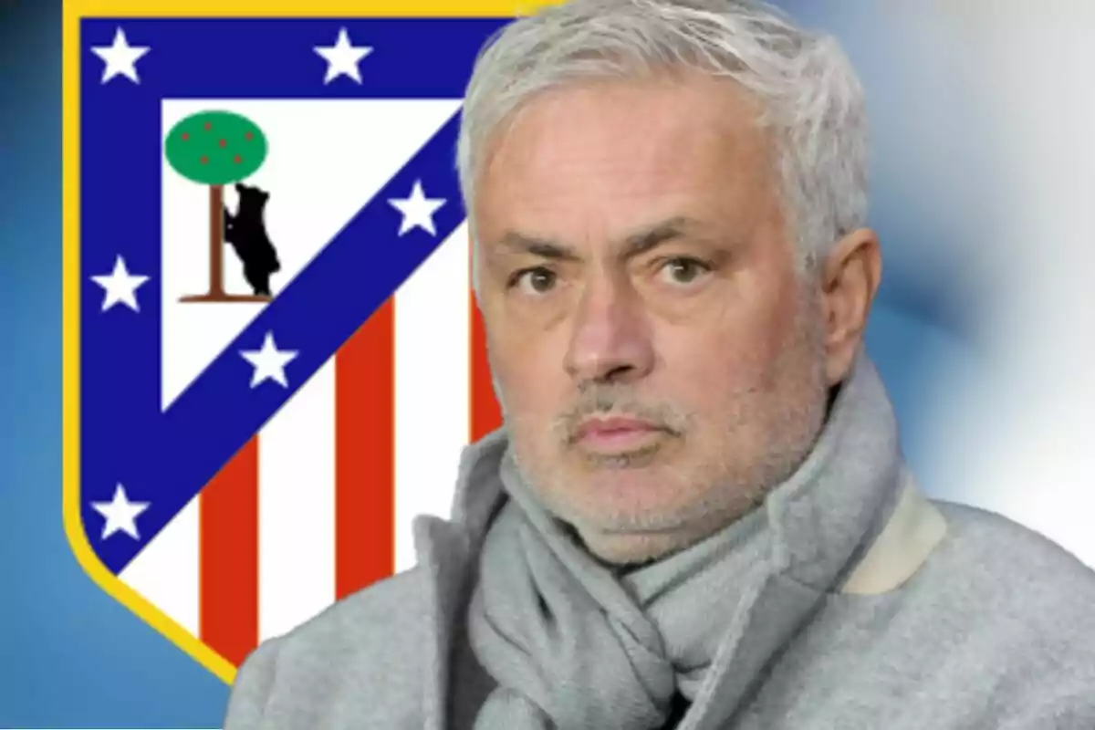 Hombre de cabello canoso con bufanda gris frente al escudo del Atlético de Madrid