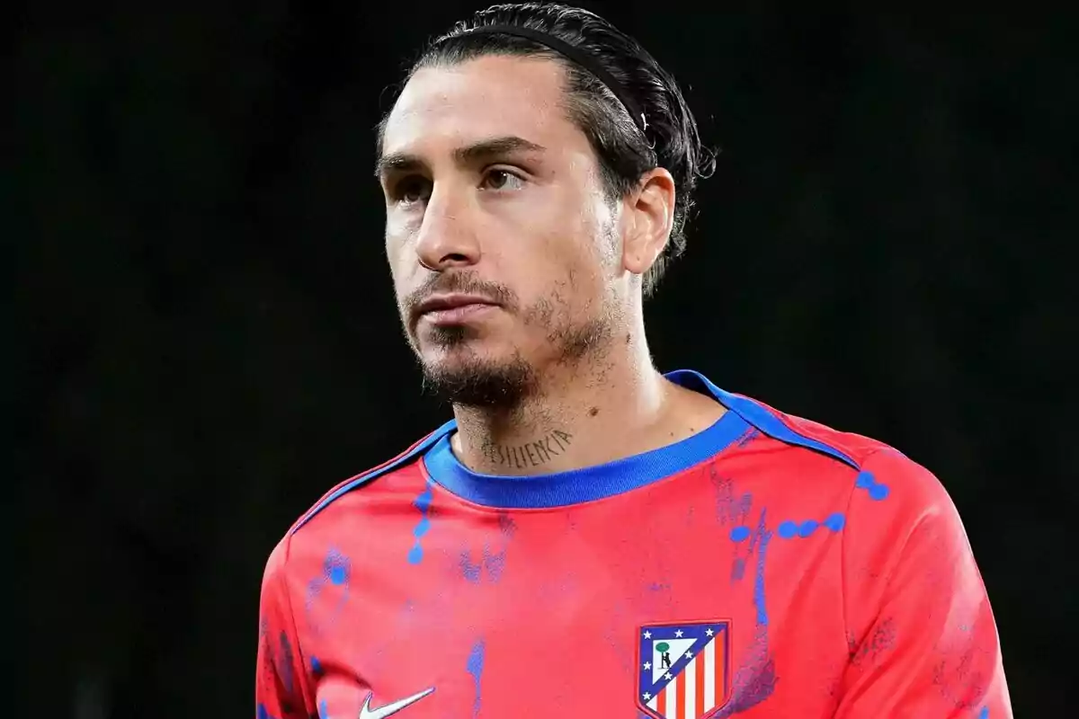 Un jugador de fútbol con una camiseta de entrenamiento roja del Atlético de Madrid.