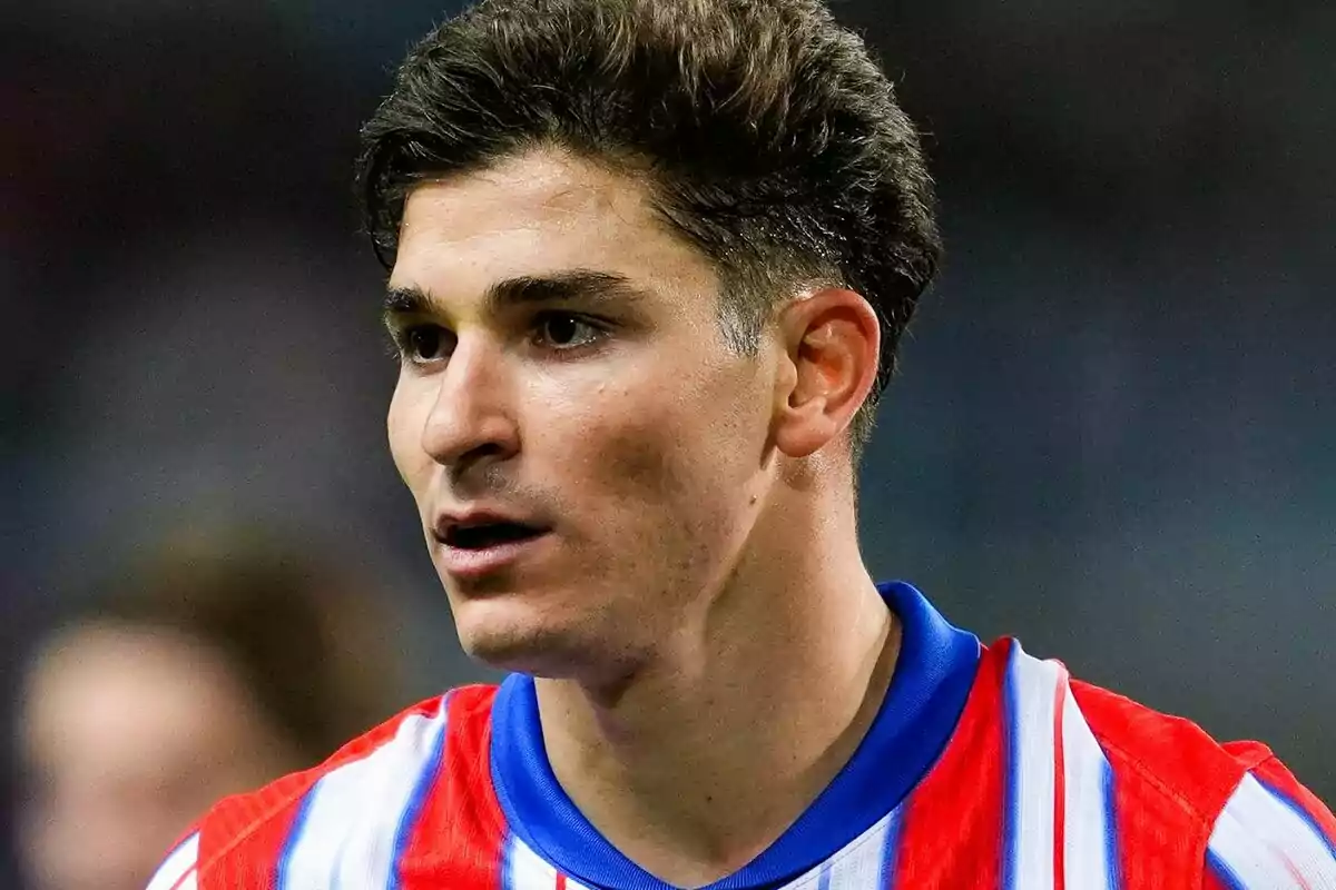 A soccer player in a red and white striped jersey during a match.