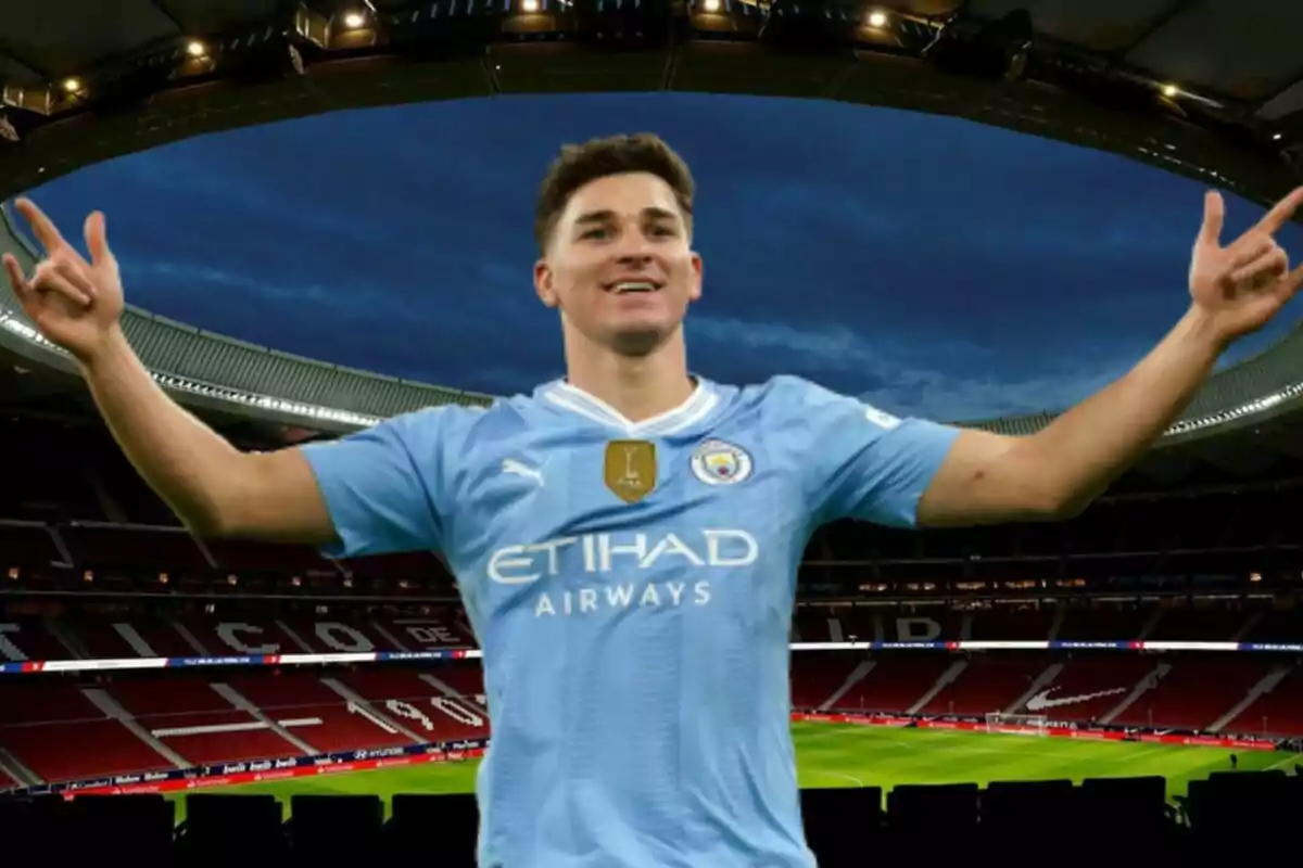 Un jugador de fútbol con uniforme celeste celebra con los brazos extendidos en un estadio iluminado.