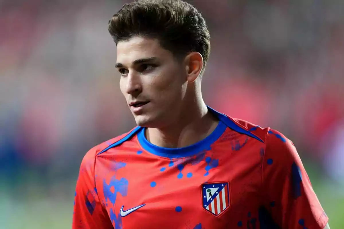 Un jugador de fútbol con la camiseta del Atlético de Madrid en un estadio.