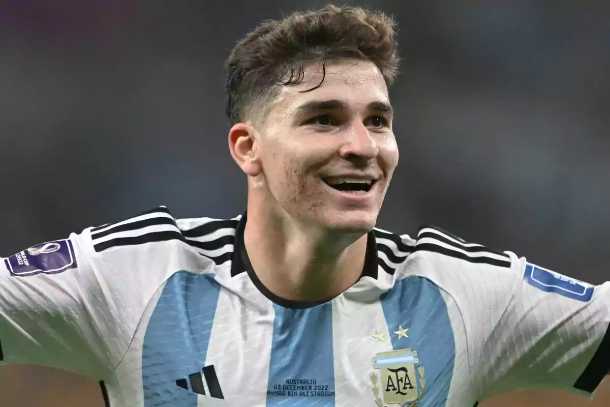 Un jugador de fútbol con la camiseta de Argentina sonríe durante un partido.