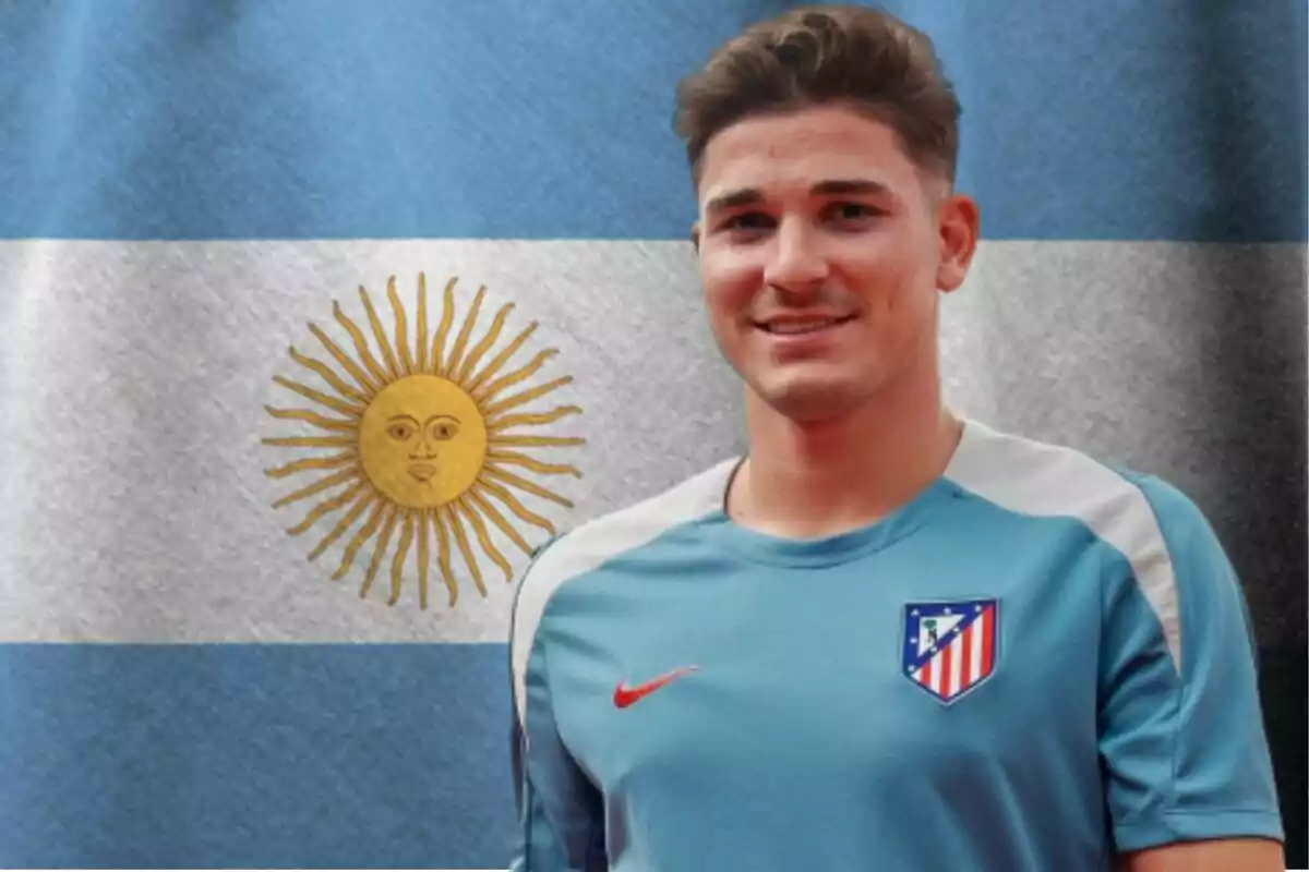 Un joven con una camiseta de entrenamiento del Atlético de Madrid está de pie frente a una bandera de Argentina.