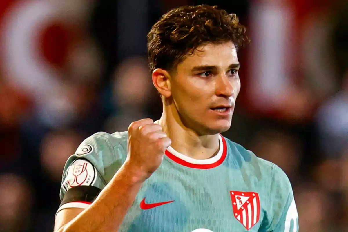 Un jugador de fútbol con uniforme del Atlético de Madrid celebra con el puño cerrado.