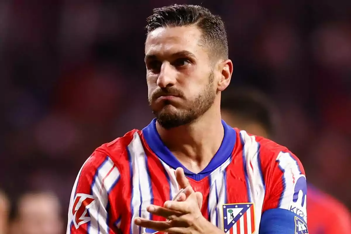 Un jugador de fútbol con uniforme rojo y blanco aplaude durante un partido.