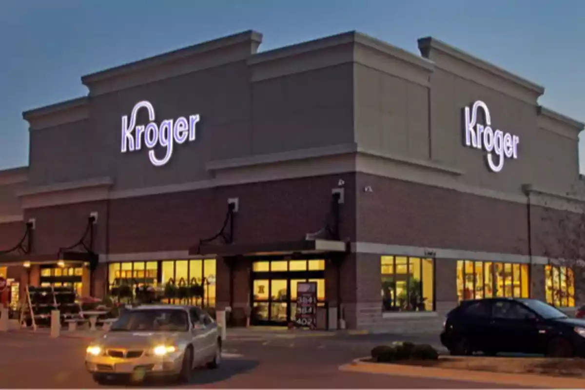 Fachada de una tienda Kroger al atardecer con autos estacionados al frente. Fachada de una tienda Kroger al atardecer con autos estacionados al frente.