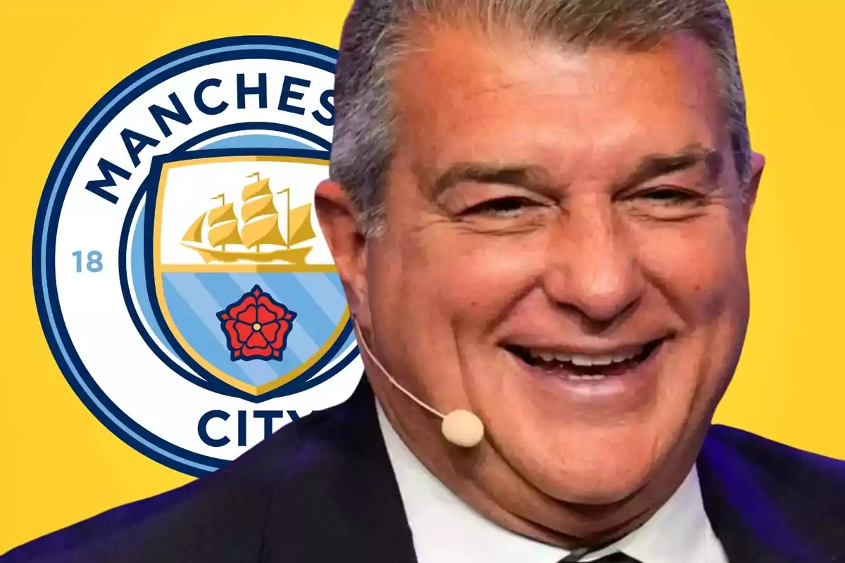 Smiling man with headset microphone in front of Manchester City logo.