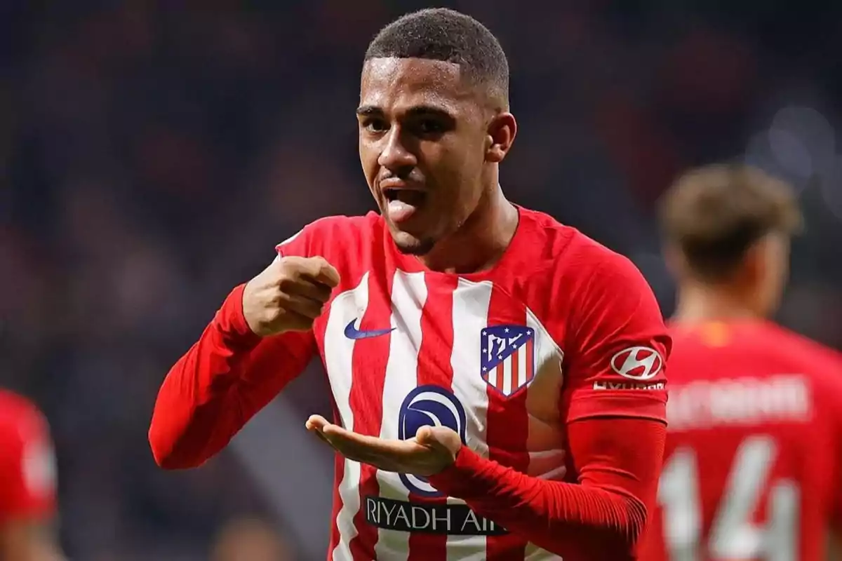 Jugador de fútbol del Atlético de Madrid celebrando un gol con un gesto en el campo.