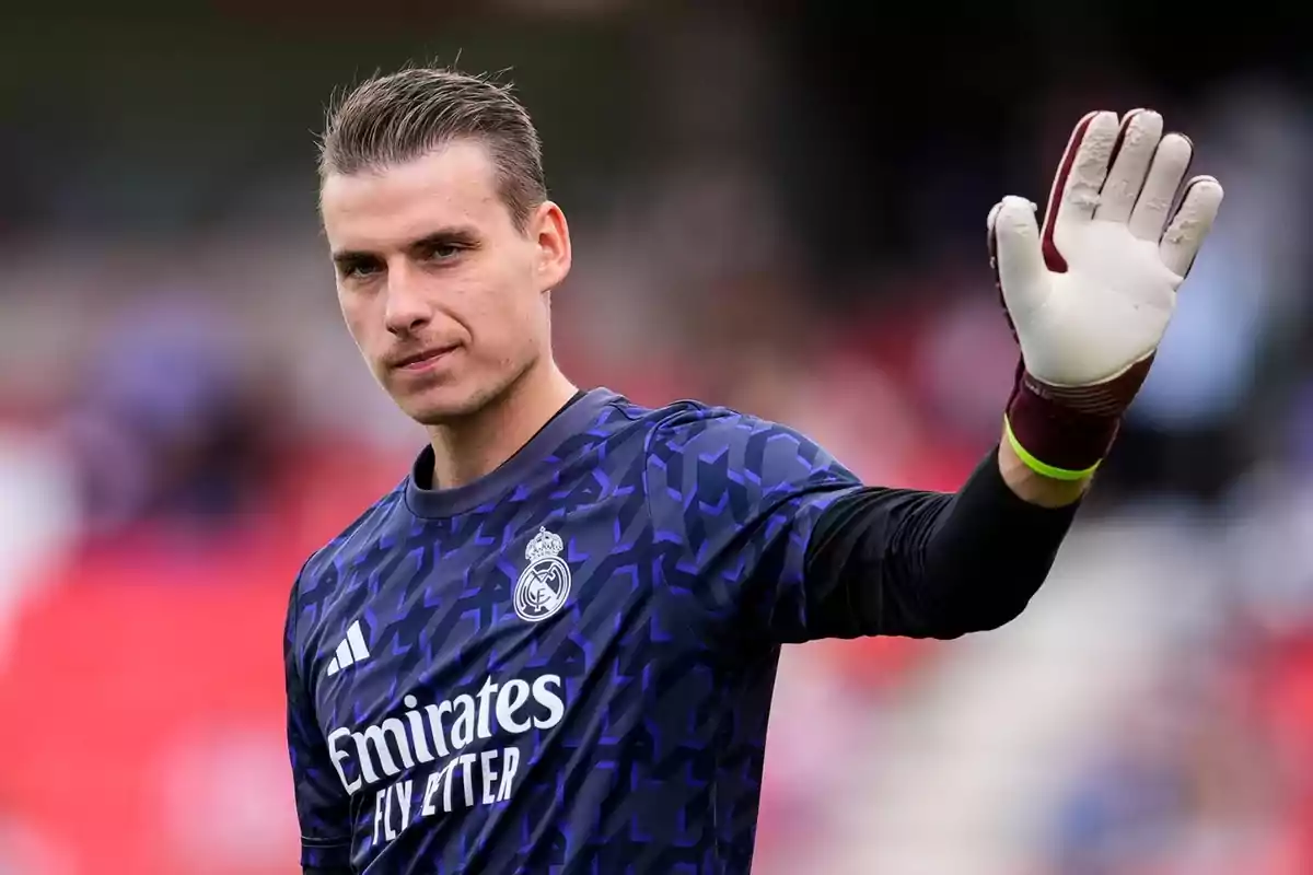 Andriy Lunin greets the fans with his gloves on and the Real Madrid warm-up shirt