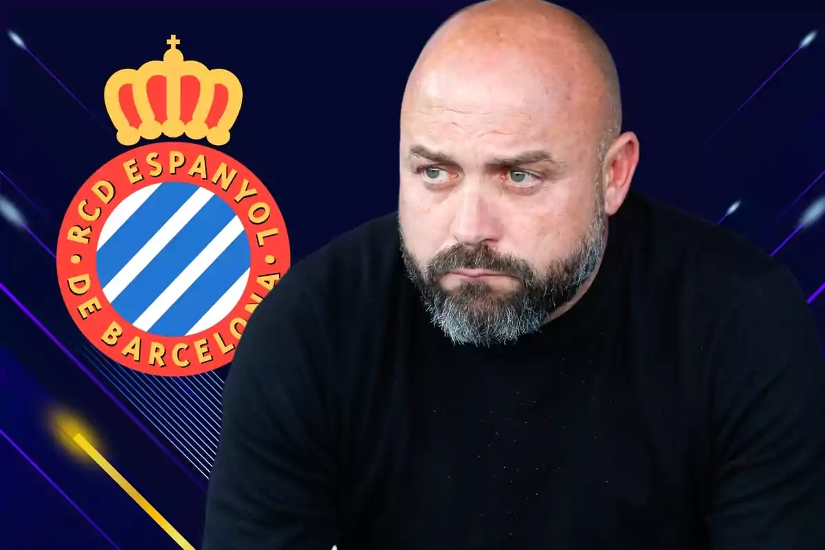 Hombre con barba y camiseta negra frente al logo del RCD Espanyol de Barcelona.