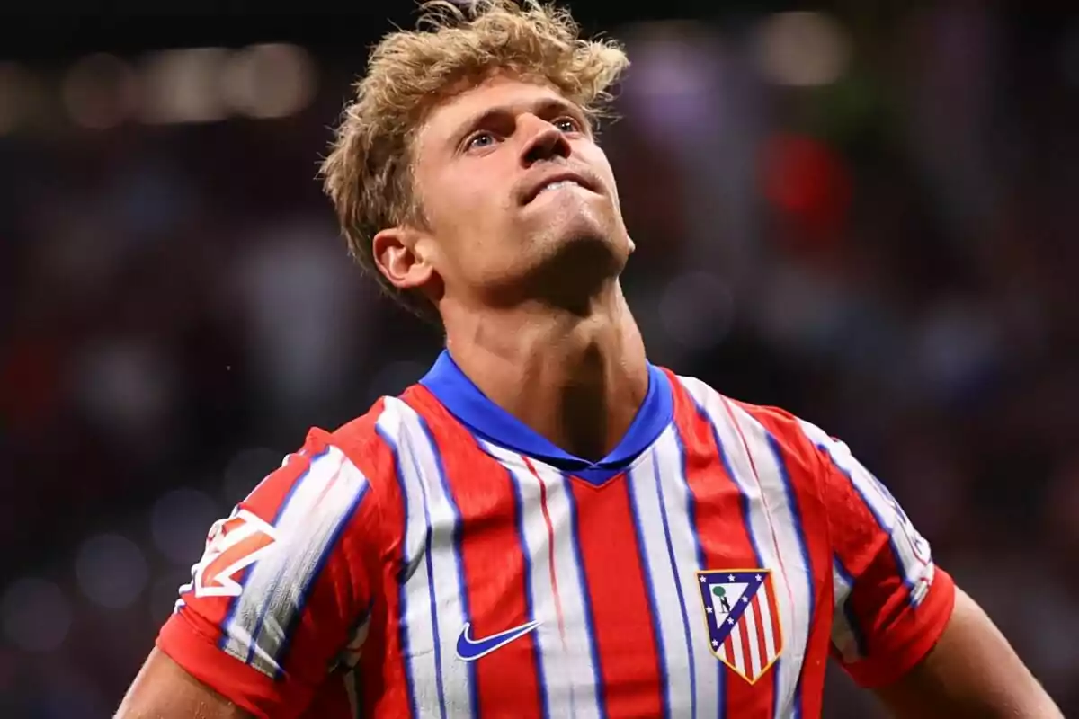 Jugador de fútbol con la camiseta del Atlético de Madrid en el campo.