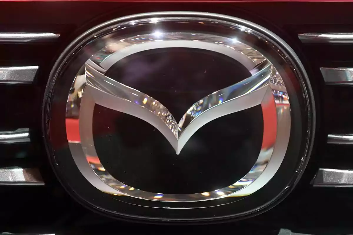 Logotipo cromado de Mazda en la parrilla de un automóvil Logotipo cromado de Mazda en la parrilla de un automóvil