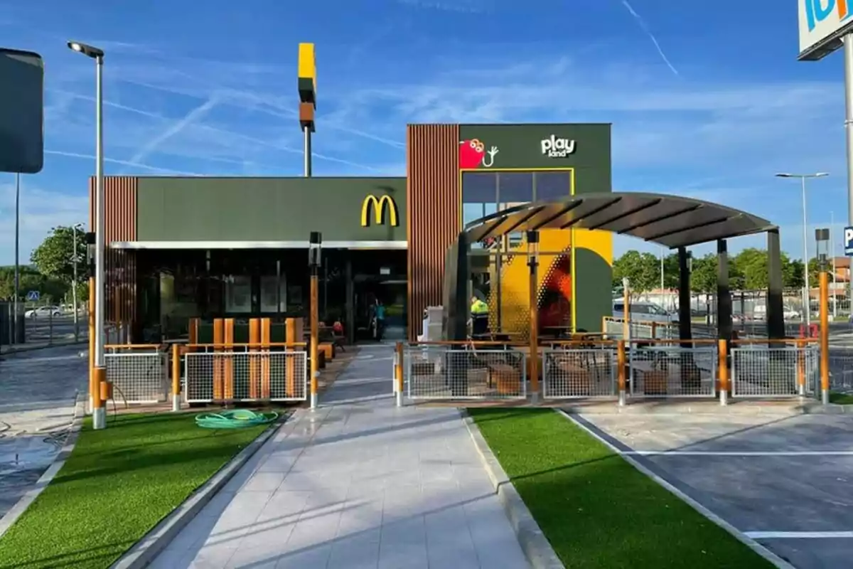 Un restaurante de comida rápida con un área de juegos al aire libre y un diseño moderno. Un restaurante de comida rápida con un área de juegos al aire libre y un diseño moderno.