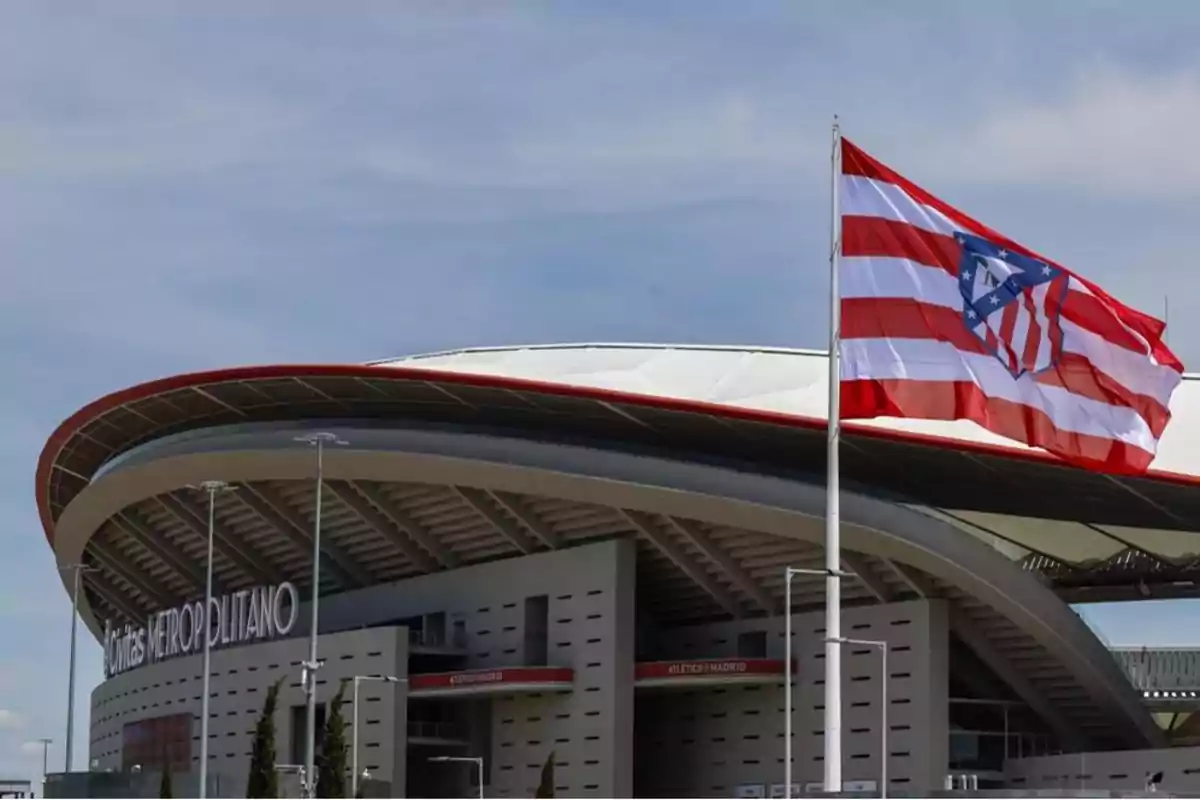 Estadio Cívitas Metropolitano con una bandera del Atlético de Madrid ondeando en primer plano.