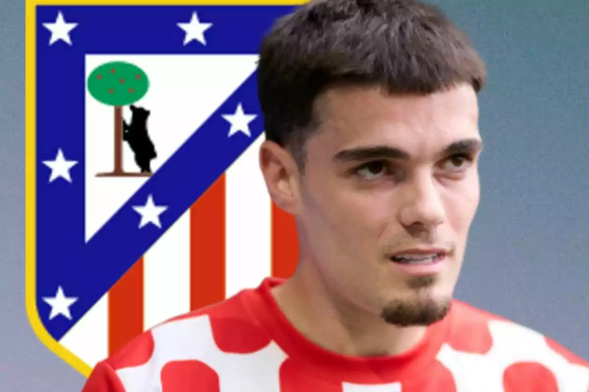 Un jugador de fútbol con la camiseta del Atlético de Madrid y el escudo del equipo de fondo.